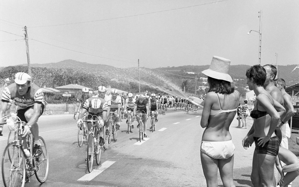 Des coureurs profitant d’un jet d’eau rafraîchissante par temps chaud (1960)