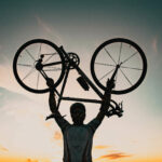 homme portant un vélo