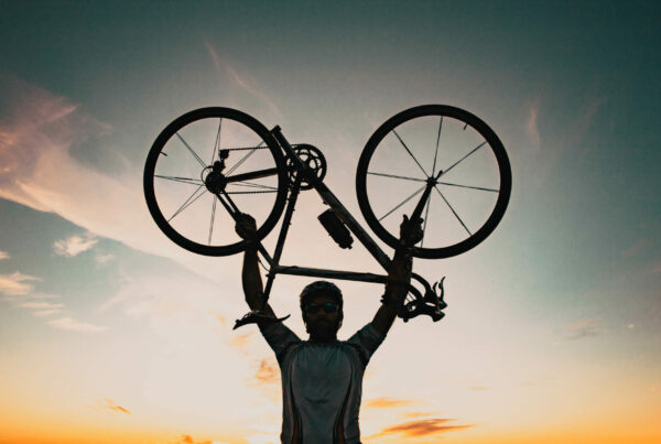 homme portant un vélo