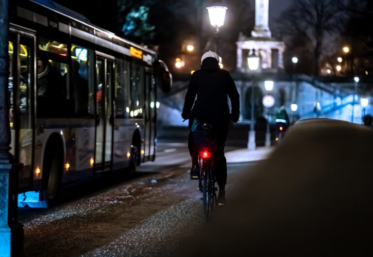 cycliste à côté d'un bus roulant de nuit