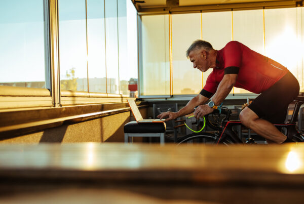 homme sur home trainer lance une sortie virtuelle sur son ordinateur