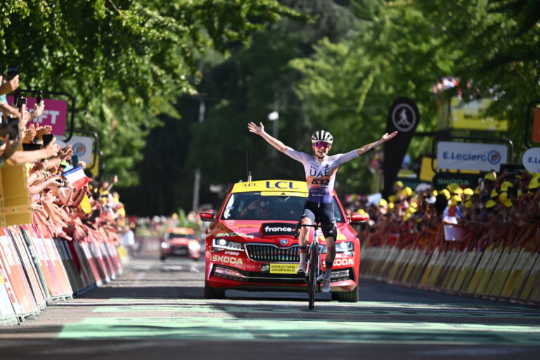 Maeva Squiban qui passe la ligne d'arrivée en tête, debout sur son vélo, les bras en l'air
