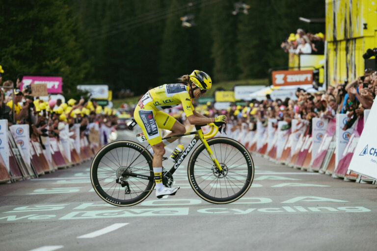 Pauline Ferrand-Prévot sur son vélo, vêtue de la combinaison jaune, franchit l'arrivée seule en tête
