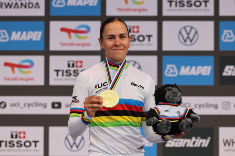 Celia Gery avec le maillot arc-en-ciel, la médaille d'or et la peluche de la mascotte de Kigali 2025